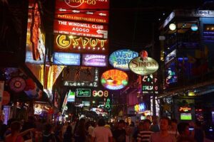 Pattaya, Thailand - October 7, 2016: Crowd of tourists on the noisy and sleazy Walking Street, Pattaya's hottest nightlife spot, surrounded by flashing advertising placards and nightclub signs.